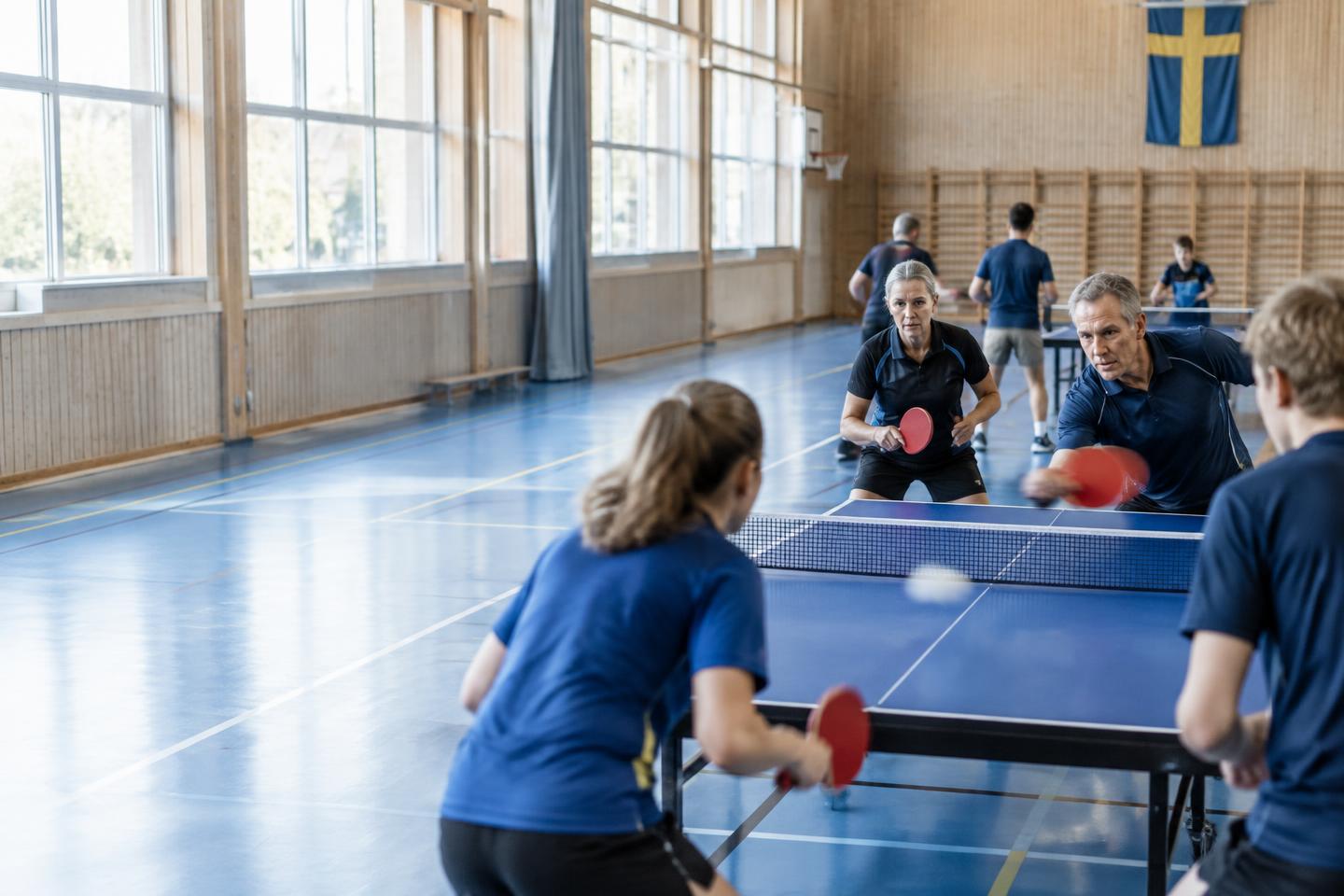 Bordtennisspelare mitt i en intensiv dubbelmatch